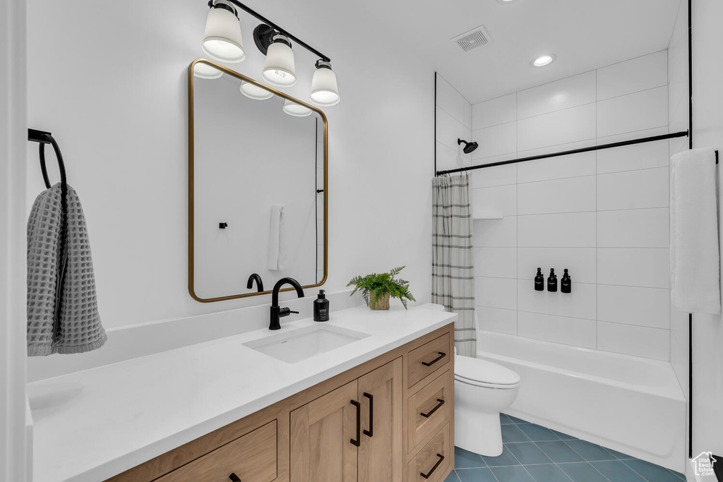 Full bathroom featuring tile floors, vanity, shower / tub combo, and toilet