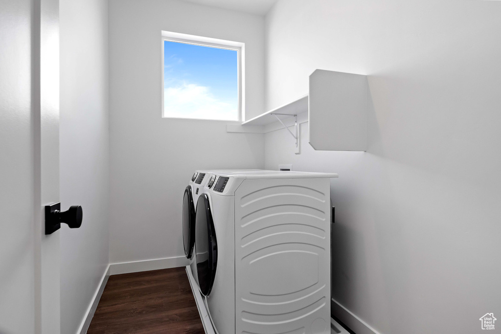 Clothes washing area featuring dark hardwood / wood-style flooring and washer and clothes dryer