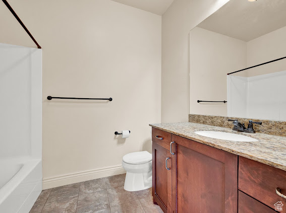 Full bathroom featuring vanity, toilet, tile floors, and tub / shower combination