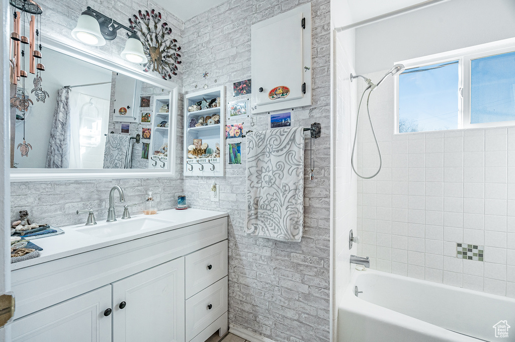 Bathroom featuring tile walls, vanity, and shower / bath combo