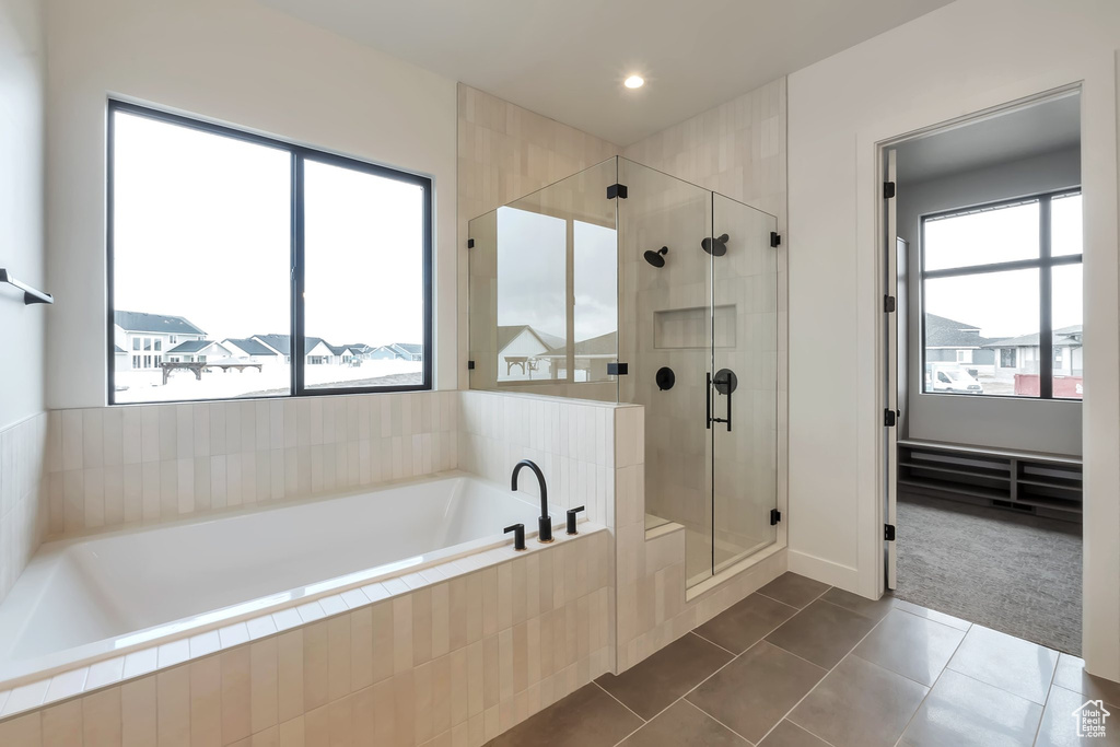 Bathroom with plenty of natural light, independent shower and bath, and tile floors
