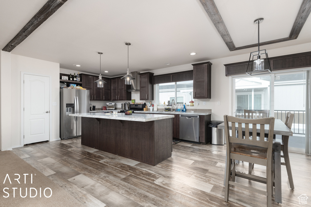 Kitchen featuring a kitchen island, appliances with stainless steel finishes, light hardwood / wood-style floors, and dark brown cabinetry
