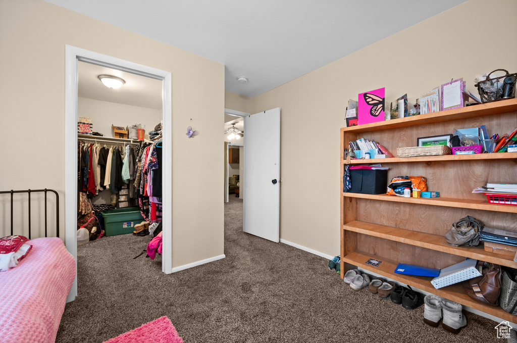 Bedroom with a closet and dark colored carpet