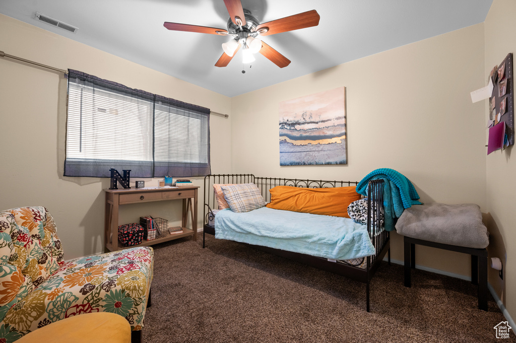 Bedroom with dark colored carpet and ceiling fan