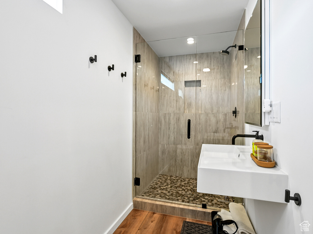 Bathroom with a shower with door and hardwood / wood-style flooring