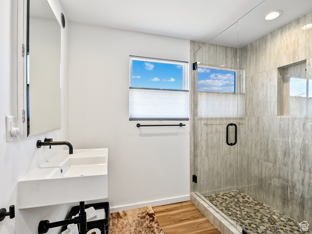 Bathroom with a shower with shower door and wood-type flooring