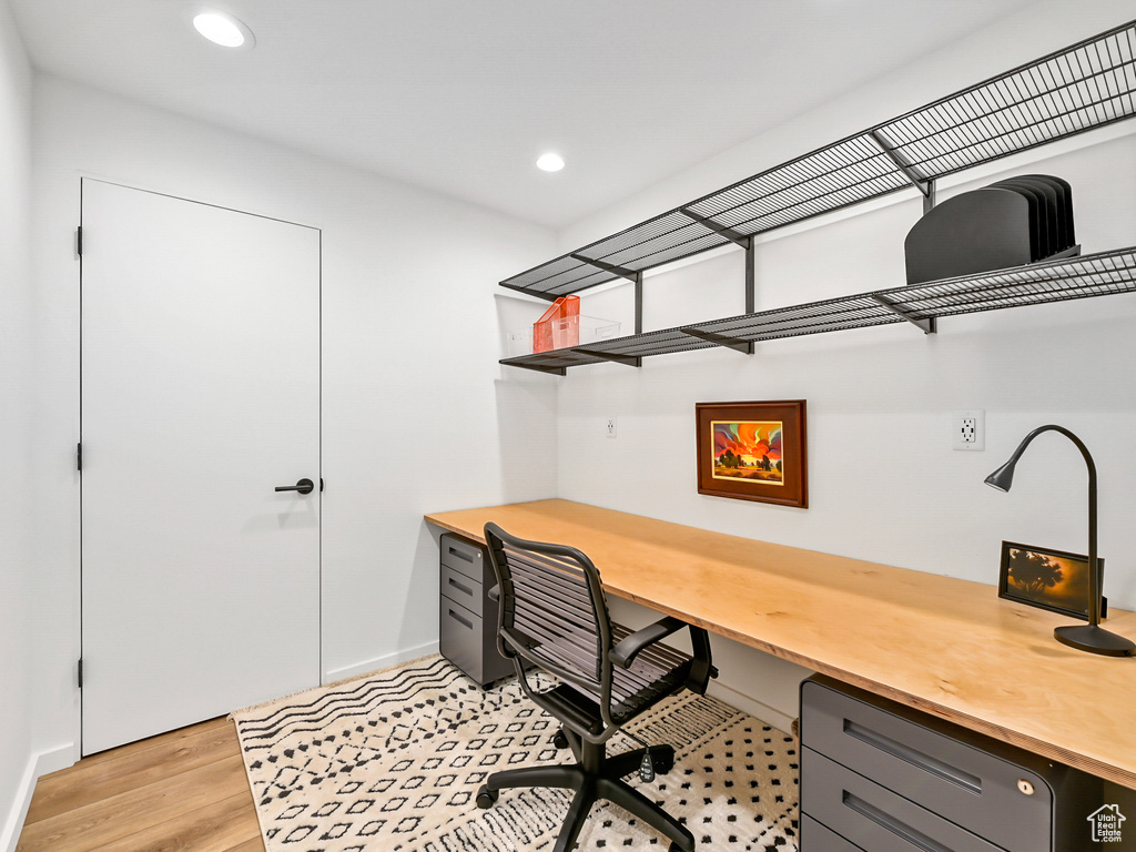 Office space with light hardwood / wood-style floors