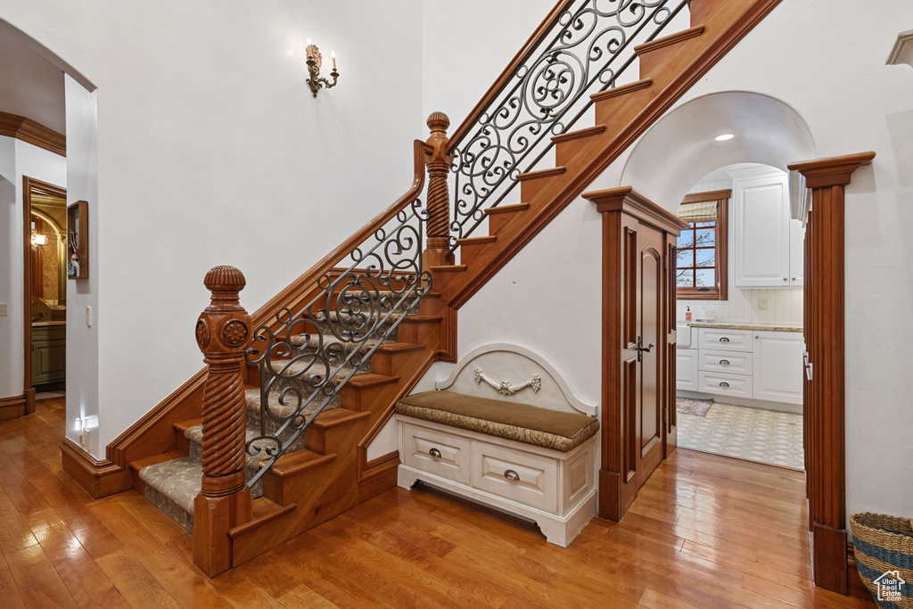 Staircase featuring light hardwood / wood-style floors and decorative columns