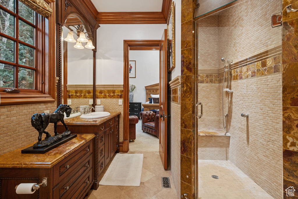Bathroom with vanity, walk in shower, tile floors, and backsplash