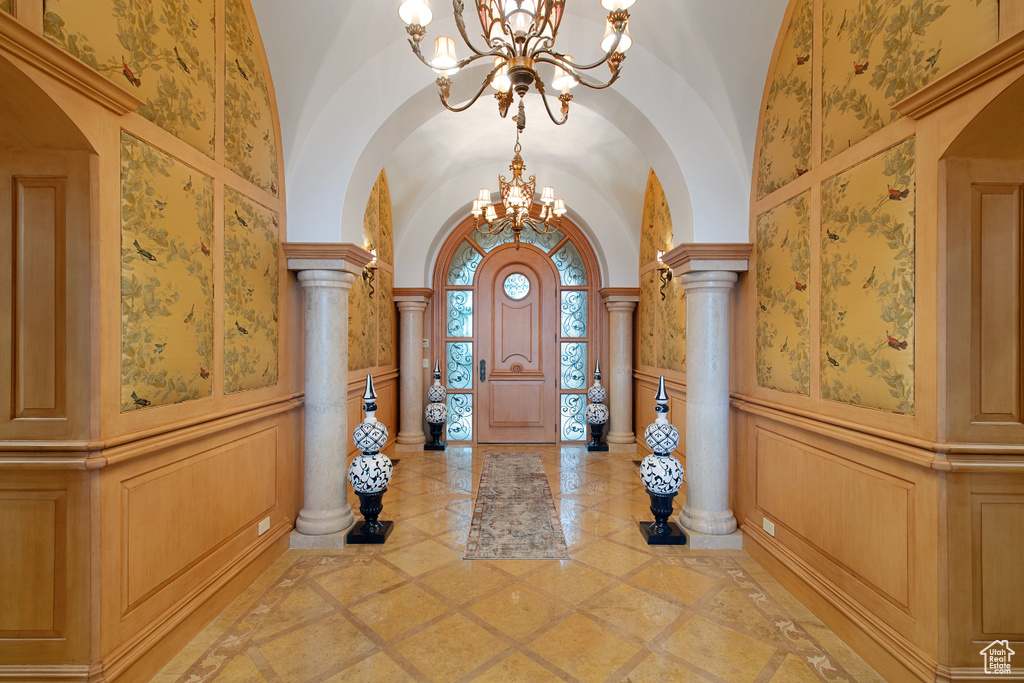 Tiled entryway featuring a chandelier and ornate columns