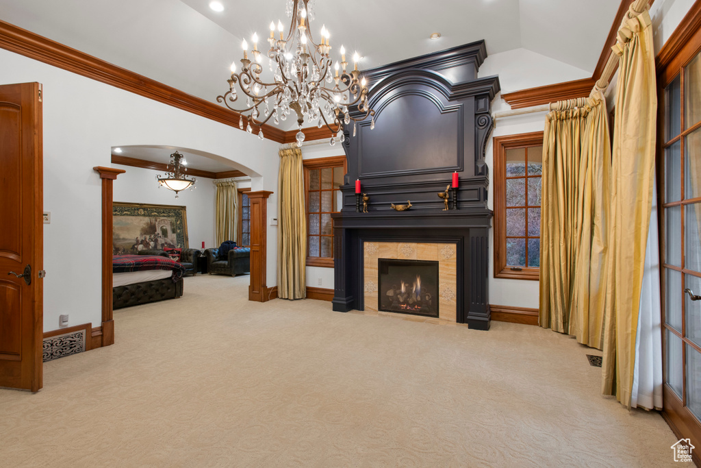 Living room featuring a chandelier, crown molding, and light carpet
