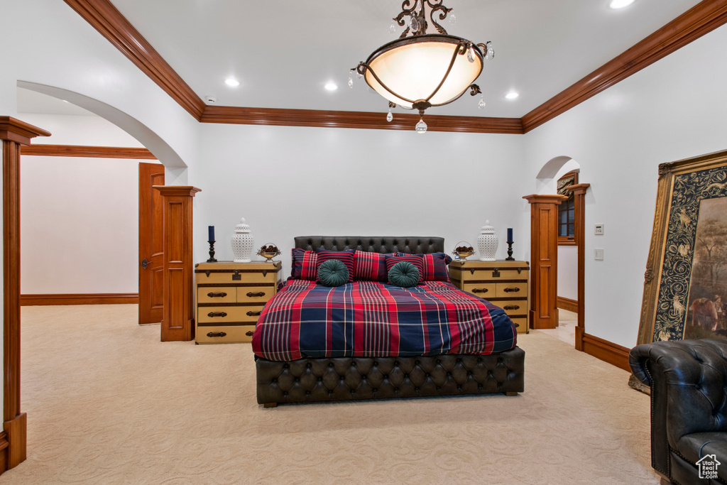 Carpeted bedroom with crown molding and ornate columns