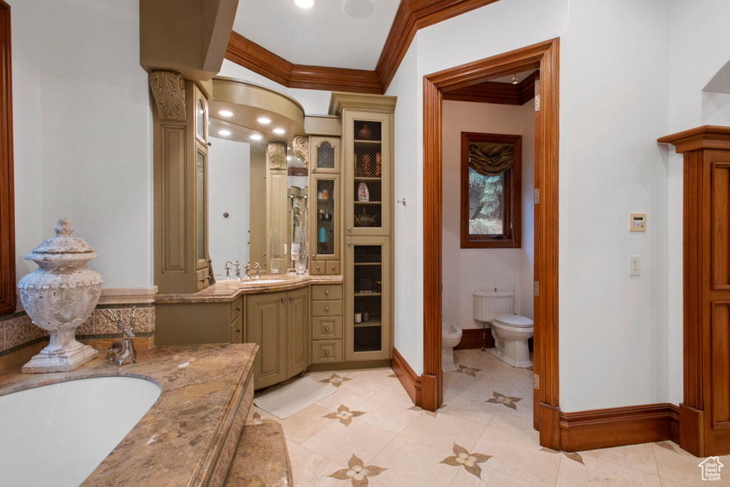 Bathroom featuring ornate columns, vanity, a bathing tub, toilet, and tile floors
