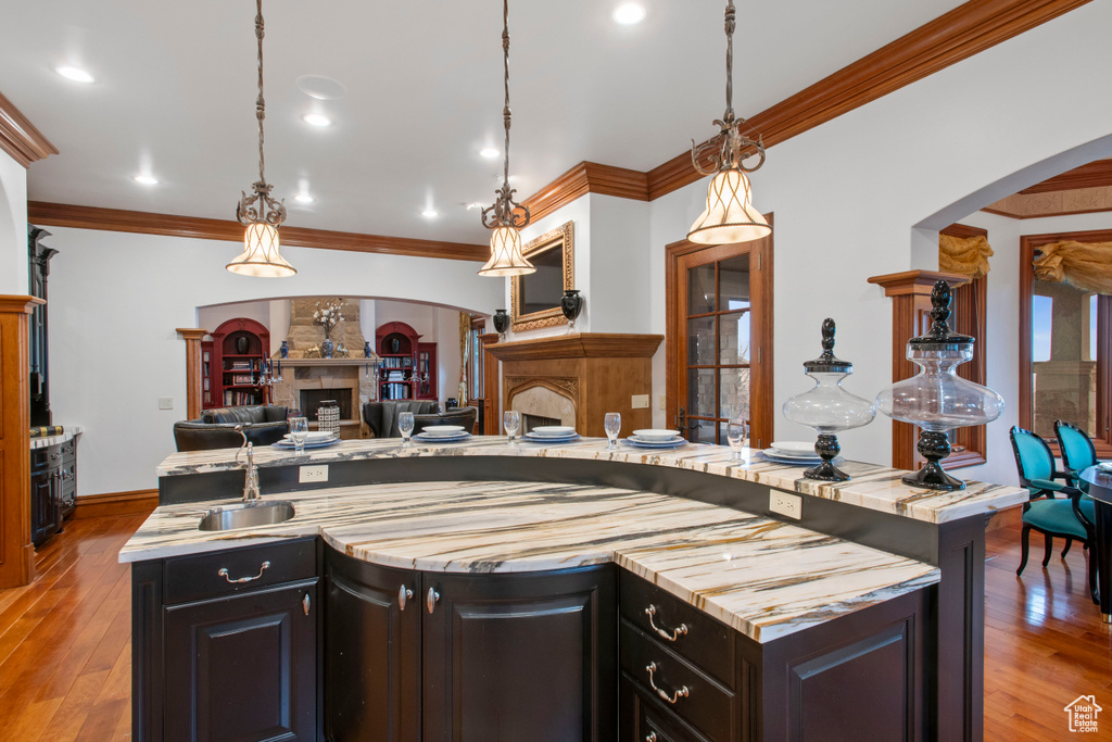 Kitchen with pendant lighting, light hardwood / wood-style flooring, and crown molding