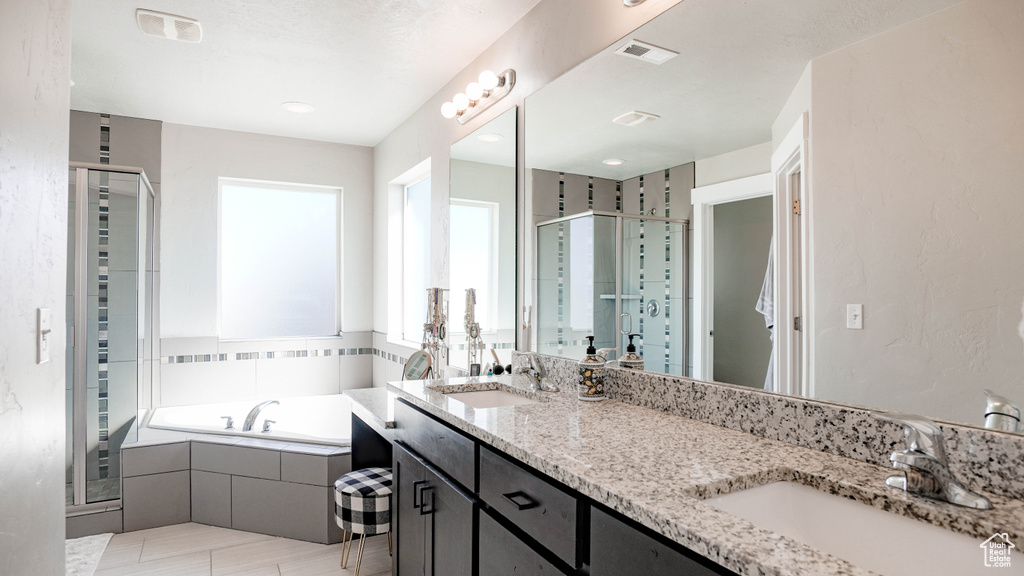 Bathroom with shower with separate bathtub, double sink, oversized vanity, and tile flooring