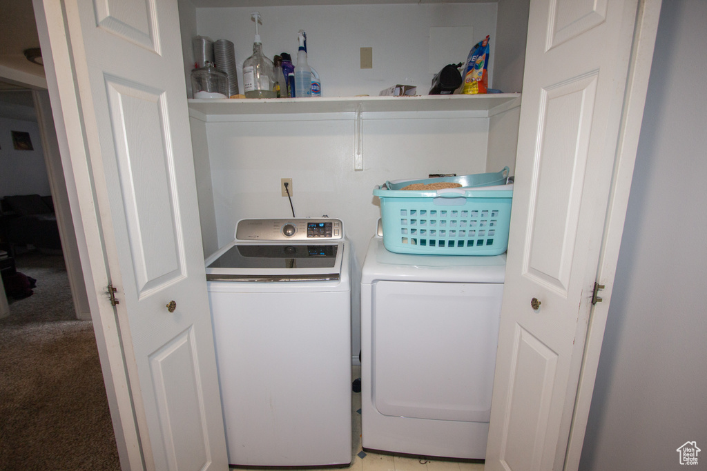 Washroom featuring washing machine and clothes dryer and light carpet