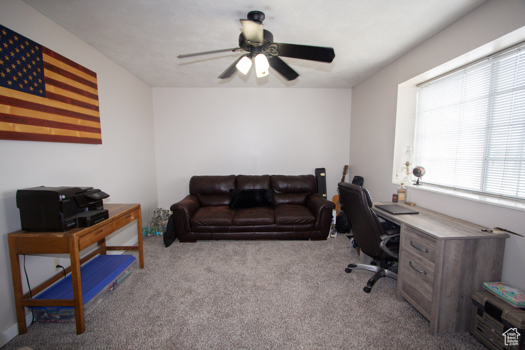 Office area with ceiling fan and light colored carpet