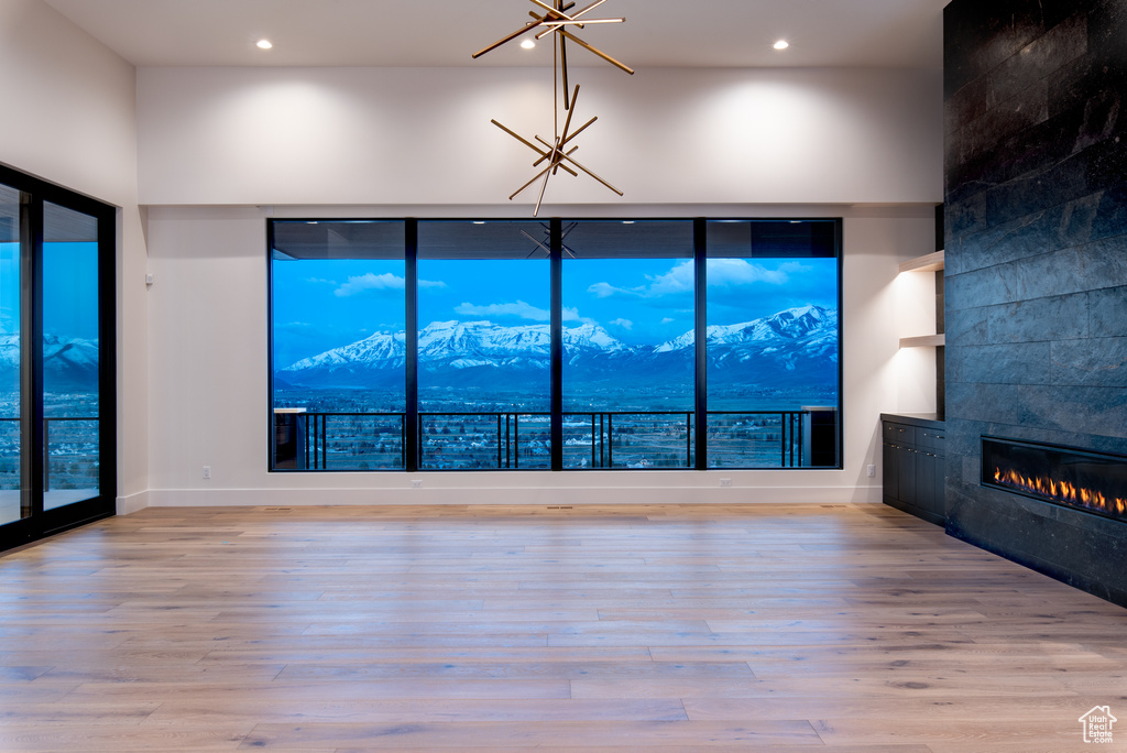 Unfurnished living room featuring a mountain view, light hardwood / wood-style flooring, and a tile fireplace