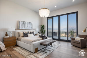 Bedroom featuring hardwood / wood-style flooring, a notable chandelier, and access to outside