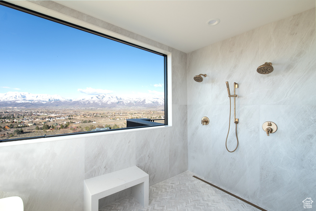 Bathroom with tiled shower, a mountain view, tile walls, and plenty of natural light