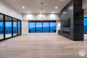 Unfurnished living room with a large fireplace, a mountain view, and hardwood / wood-style flooring