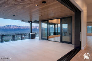 Snow covered patio featuring a balcony and a mountain view