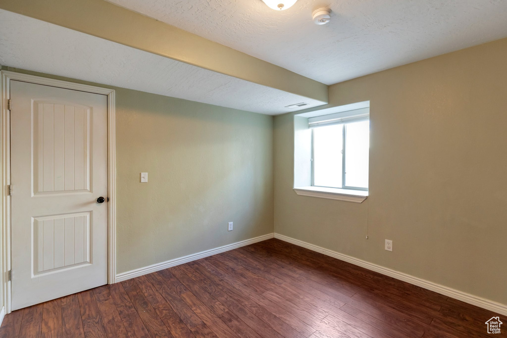 Empty room featuring dark hardwood / wood-style floors