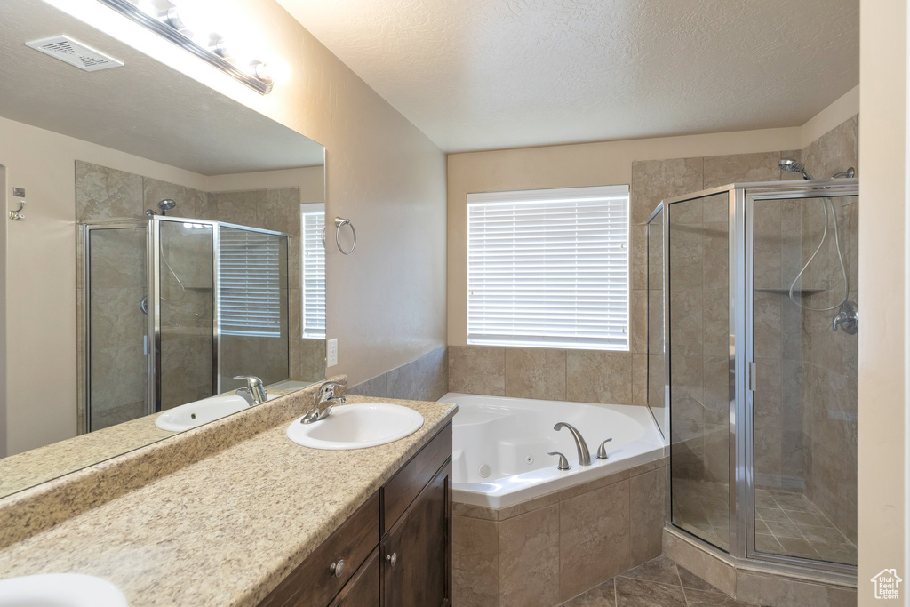 Bathroom with dual bowl vanity, tile floors, plus walk in shower, and a textured ceiling