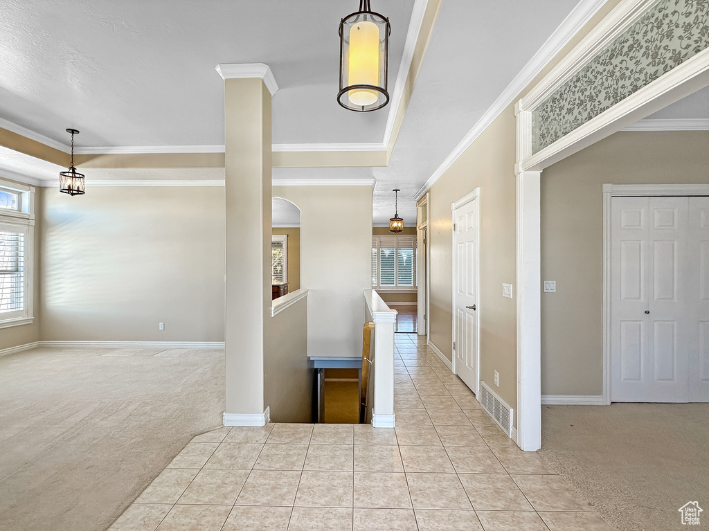 Interior space with crown molding and light carpet