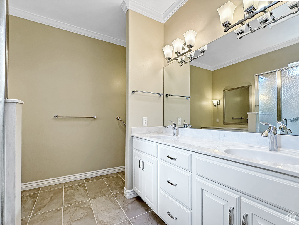 Bathroom with crown molding, double sink vanity, and tile flooring