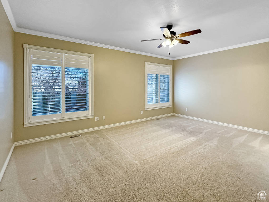 Carpeted empty room with crown molding and ceiling fan