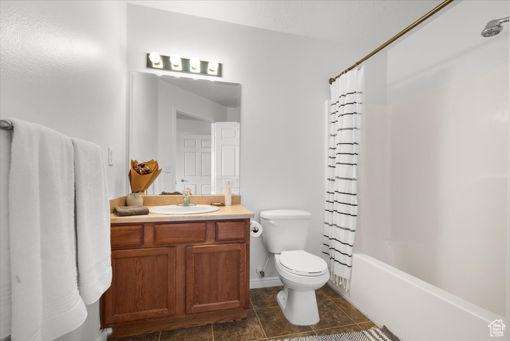 Full bathroom with tile flooring, vanity, shower / tub combo, and toilet