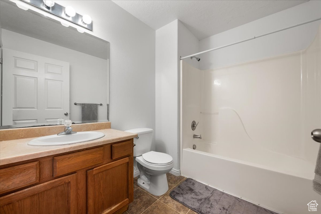Full bathroom with vanity, toilet, shower / bath combination, and tile floors