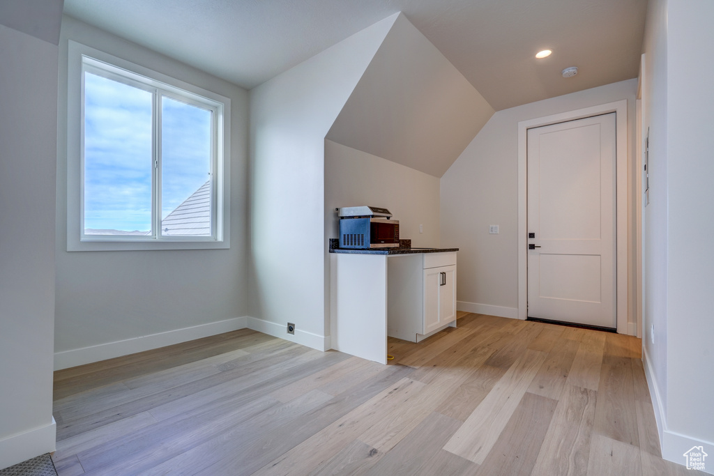 Bonus room featuring light wood-type flooring and lofted ceiling