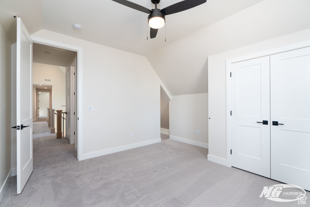 Bonus room with ceiling fan, light colored carpet, and lofted ceiling