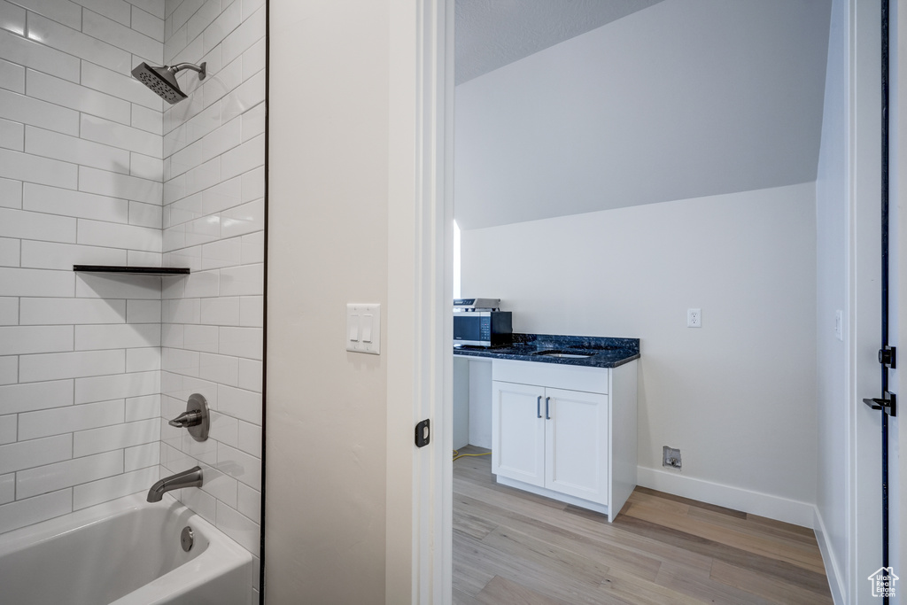 Bathroom featuring vanity, hardwood / wood-style floors, and tiled shower / bath