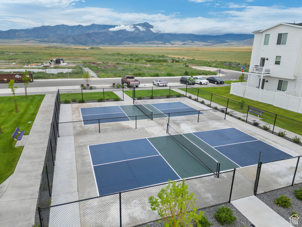 View of sport court with a yard and a mountain view