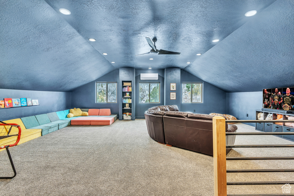 Carpeted cinema featuring a healthy amount of sunlight, ceiling fan, a textured ceiling, and lofted ceiling