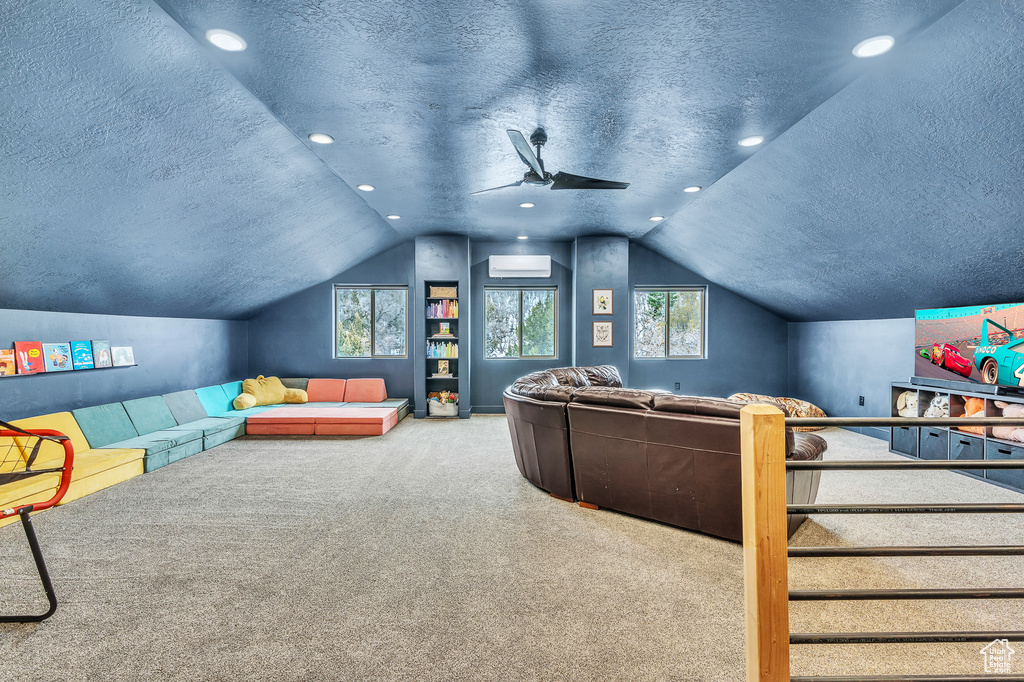 Carpeted cinema room featuring plenty of natural light, ceiling fan, a textured ceiling, and vaulted ceiling