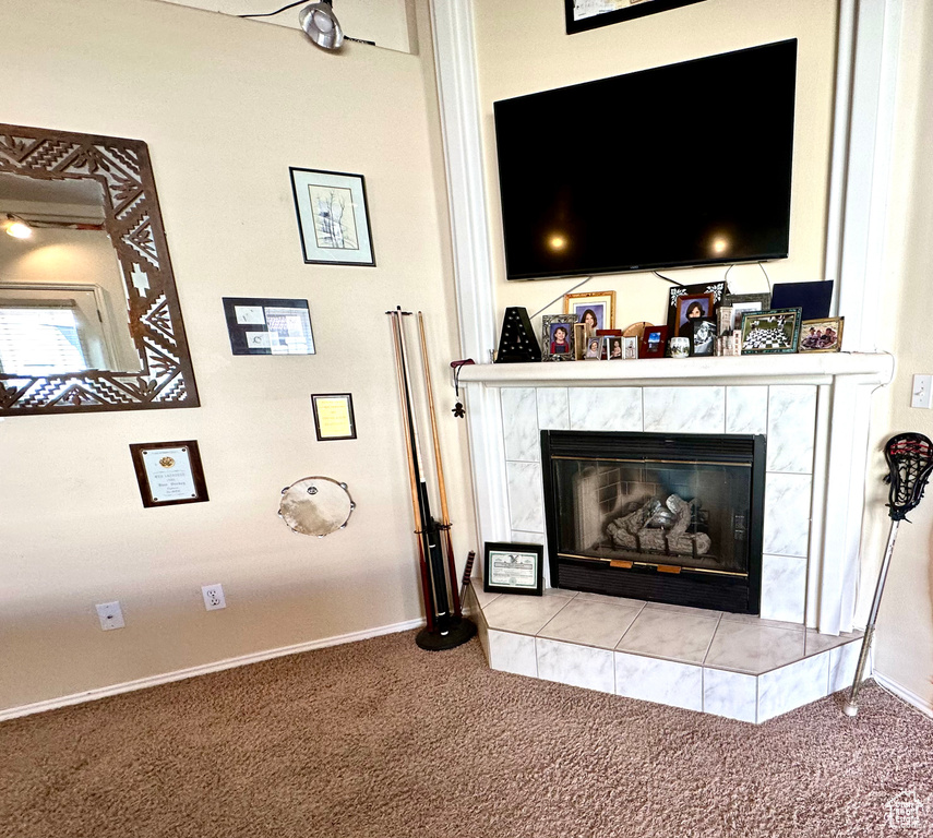 Interior details featuring light colored carpet and a tile fireplace