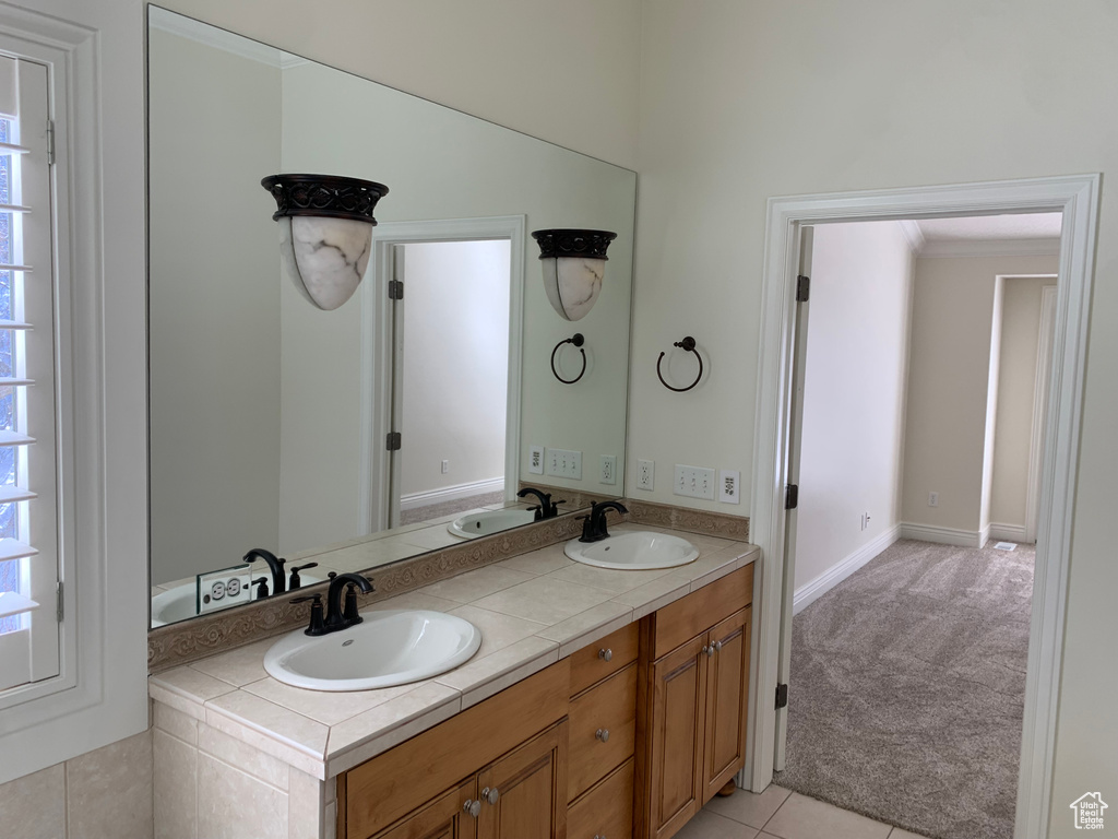 Bathroom with plenty of natural light, double sink, oversized vanity, and tile flooring