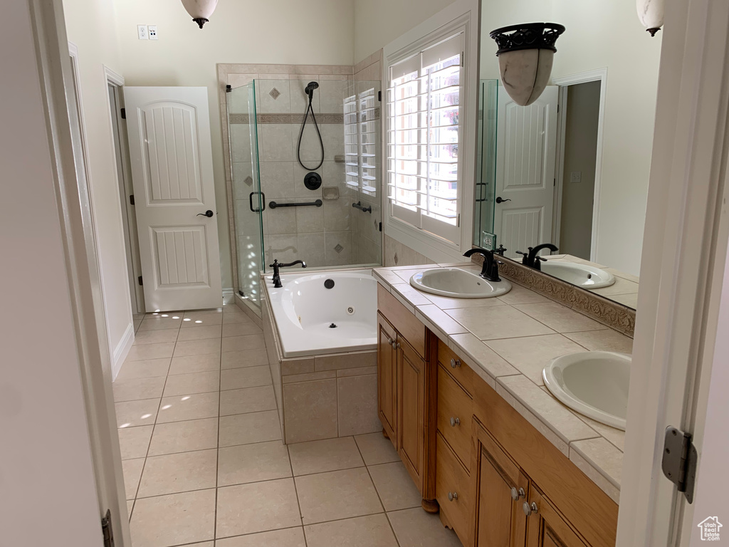 Bathroom with shower with separate bathtub, dual bowl vanity, and tile flooring