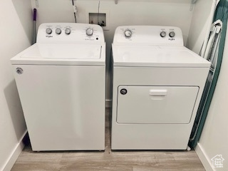 Laundry room with washer hookup, light hardwood / wood-style flooring, and washer and clothes dryer