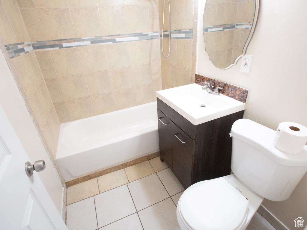 Full bathroom featuring tiled shower / bath, vanity, tile flooring, and toilet