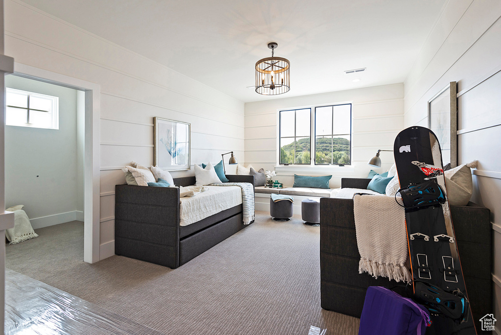 Carpeted bedroom featuring a chandelier