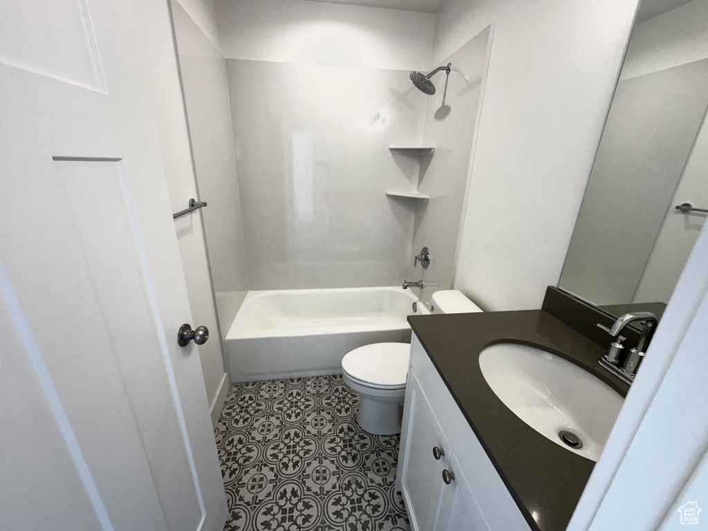 Full bathroom featuring oversized vanity, washtub / shower combination, tile floors, and toilet