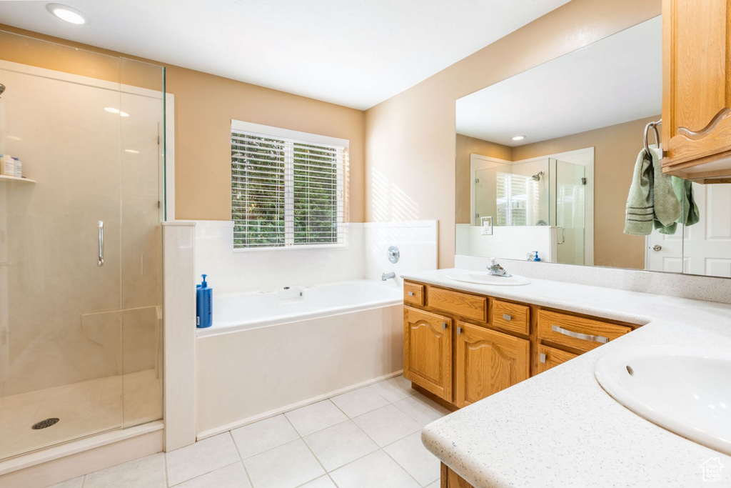 Bathroom with large vanity, tile floors, and independent shower and bath