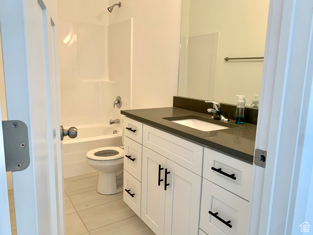 Full bathroom with tile floors, bathing tub / shower combination, large vanity, and toilet