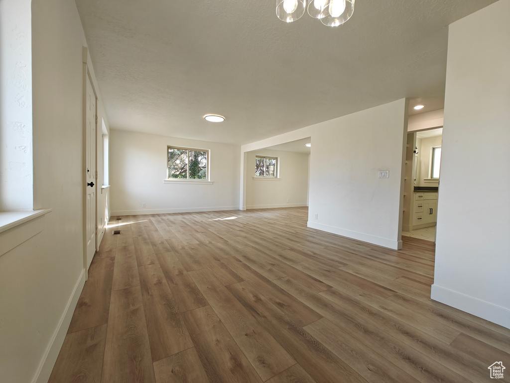 Unfurnished room featuring dark hardwood / wood-style flooring and a notable chandelier