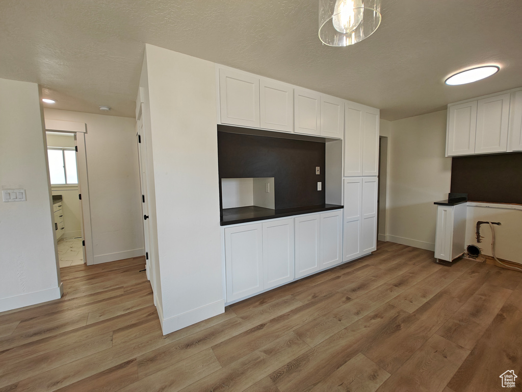 Kitchen featuring light hardwood / wood-style floors and white cabinetry